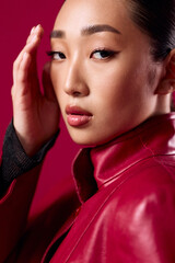 Wall Mural - Fashion, asian, brunette woman in red leather jacket posing with hand on head and red lipstick