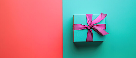 Wall Mural - A gift box with a ribbon on the top, against a vibrant background, in a top-down view