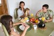 © Taras Grebinets - Family enjoying a healthy breakfast together at home with fresh fruits and juice on the table, creating a warm and loving atmosphere