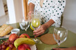 © Taras Grebinets - Woman preparing a healthy breakfast table with fresh fruits, bread, and juice in a cozy home setting, emphasizing healthy living and morning routines