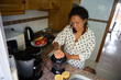 © Taras Grebinets - Woman preparing fresh lemon juice in a cozy kitchen, adding a touch of health to her morning routine