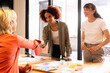 © Wavebreak Media - Shaking hands, multiracial businesswomen collaborating on creative project in modern office