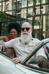 Poster - A man with a white beard and tattoos sits in a convertible. AI.