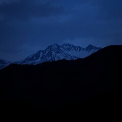 Wall Mural - Silhouetted mountains under a deep blue sky