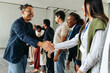 © Jacob Lund - Business professionals shaking hands and networking in an office setting