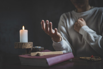 Woman praying while holding Bible and cross, Pray in the Morning , Woman praying with hands together on the Sunrise background.