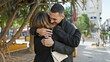 © Krakenimages.com - A loving couple embraces in a tree-lined city park, exemplifying a beautiful outdoor relationship moment for a man and woman.