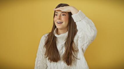 Poster - Young hispanic woman with long hair wearing a white sweater over a yellow background, looking away with a hand over her eyes