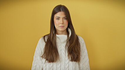 Canvas Print - Young hispanic adult woman with a beautiful hairstyle posing confidently against an isolated yellow background.