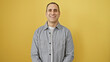 © Krakenimages.com - Handsome hispanic man smiling confidently against a vibrant yellow background, evoking positivity and charm