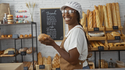 Woman smiling in a bakery holding bread surrounded by shelves of fresh pastries and baguettes in an indoor shop setting