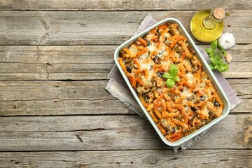 Delicious al forno pasta in baking dish on wooden table, top view. Space for text