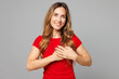 © ViDi Studio - Young smiling kind-hearted grateful thankful happy woman she wear red t-shirt casual clothes put folded hands on heart look camera isolated on plain grey background studio portrait. Lifestyle concept.