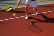 © st.kolesnikov - Male tennis player hits difficult ball close-up on tennis court background, tennis game concept