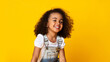 © Prostock-studio - Laughing cute afro girl portrait, kid hearing joke over yellow studio background