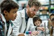 © Alena - A man in a lab coat works with children on a science project, emphasizing learning and discovery
