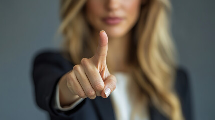 Businesswoman in suit pointing with gesture finger at camera on dark background. woman points to virtual search bar. Making a choice, touching touch screen. information technology, search engine