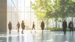 © sungedi - Silhouetted Figures Walking Through a Modern Glass Building with a Lush Green View