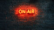 © EJManzaneque - Dark background of a brick wall with a neon sign saying “On Air”.