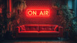 © EJManzaneque - Background of a room with a red leather sofa with a neon sign that says “On Air” above it.