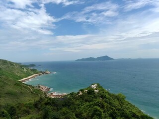 Wall Mural - Scenic coastal view with lush green hills and distant islands.