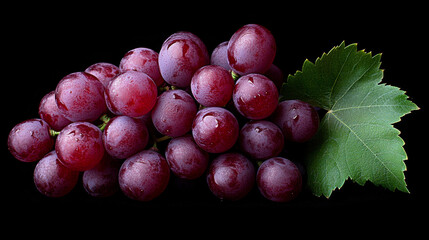 Ripe red grapes with leaves create vibrant and fresh appearance against black background, showcasing their juicy texture and rich color