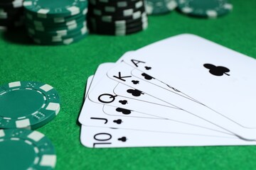 Sticker - Playing cards and poker chips on green table, selective focus