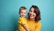 © Ali Hamza Tullah - Woman in yellow clothes have fun posing with cute child baby boy 4-5 years old. Mommy little kid son isolated on blue background studio portrait. Mother's Day love family parenthood childhood concept.