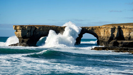 Wall Mural - Rock formation jutting out over the ocean with waves crashing below