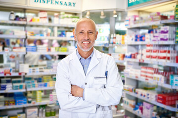 Canvas Print - Pharmacy, man and portrait with arms crossed at dispensary for healthcare, medication or prescription. Mature pharmacist, happy and medical worker with smile for pharmaceutical, service or confidence