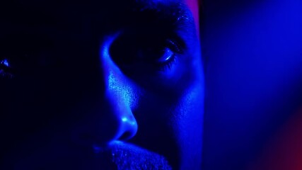 mysterious blue light illumination on man's face close-up in darkness