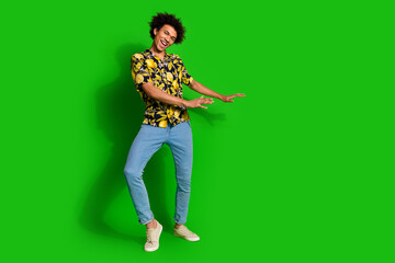 Poster - Photo of cheerful optimistic man wear stylish print clothes dance empty space isolated on green color background