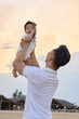 © Tuan - a man holding a baby up in the air