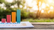 © Gibster - Close up of business forecast document featuring colorful bar graphs, showcasing growth and analysis in natural setting. warm sunlight enhances optimistic atmosphere