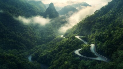 High-resolution shot of a serpentine mountain road cutting through dense forests, with mist rolling over the peaks and a dramatic sky overhead