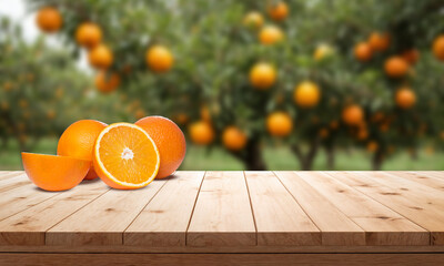 Wall Mural - Rustic wooden table top with blurred background of the orange fruit plantation farm in summer sun