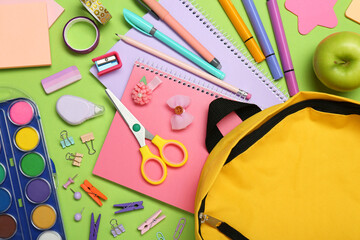 Sticker - Backpack, different school stationery and apple on light green background, flat lay