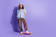 © deagreez - Full size photo of pretty retired woman ride skateboard wear trendy denim hipster outfit isolated on violet color background