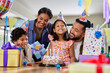 © Rido - Multiethnic family celebrating girl birthday with party at home