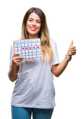 Sticker - Young beautiful woman holding menstruation calendar over isolated background happy with big smile doing ok sign, thumb up with fingers, excellent sign