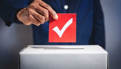 Human hand putting red check mark into ballot box