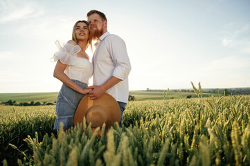 Closeness, embracing each other. Lovely couple are on the green agricultural field together