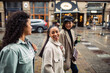 © Davor - Three diverse female friends walking together on city street