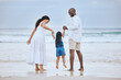 © Flashizzle/peopleimages.com - Happy family, child and bonding with daughter on holiday or travel by ocean for fun, playful and together. Beach, people and vacation on weekend for adventure, freedom and nature in summer or outdoor