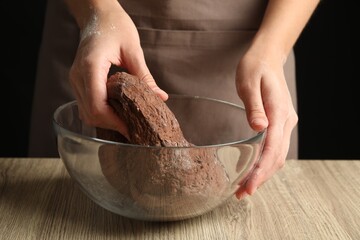 Poster - Woman kneading chocolate dough at wooden table, closeup