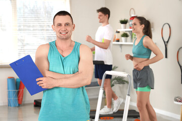 Wall Mural - Male coach with clipboard in gym