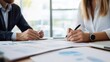 © SITTAKAN - Professional financial advisor consulting with clients, modern office setting, charts and financial plans on the table, business wealth management