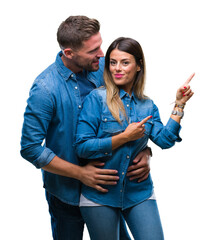 Wall Mural - Young couple in love over isolated background smiling and looking at the camera pointing with two hands and fingers to the side.