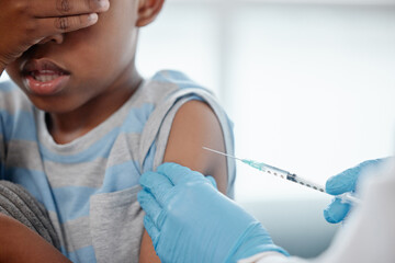 Healthcare, scared child or doctor with syringe for vaccine, injection or medicine in clinic. Kid, expert hand or PPE in practice for healing, protection or virus prevention or anxiety for medication