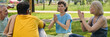 © pressmaster - Long exposure of women keeping their hands put together while sitting on mats in front of intercultural elderly men and showing new exercise